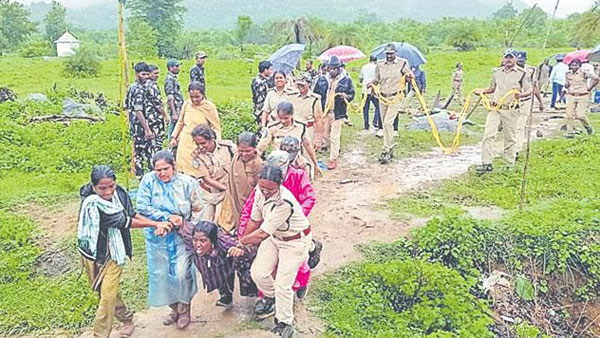జోరున వర్షంలోనూ ఆదివాసీల గుడిసెల తొలగింపు... కర్రలు, కారంపొడితో తిరగబడ్డ ఆదివాసీలు