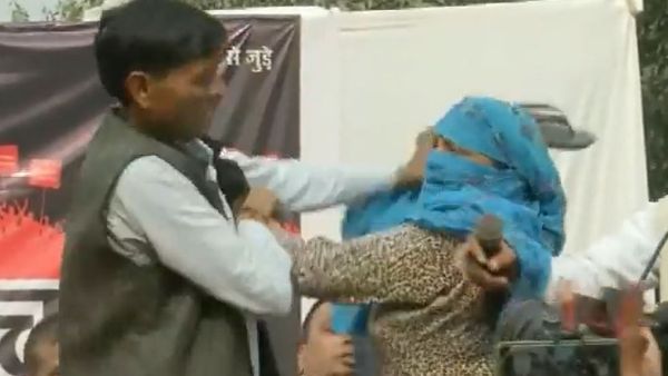 Woman climbs up the stage of Hindu Ekta Manchs program and hits a man with her slippers Woman climbs up the stage of Hindu Ekta Manchs program and hits a man with her slippers