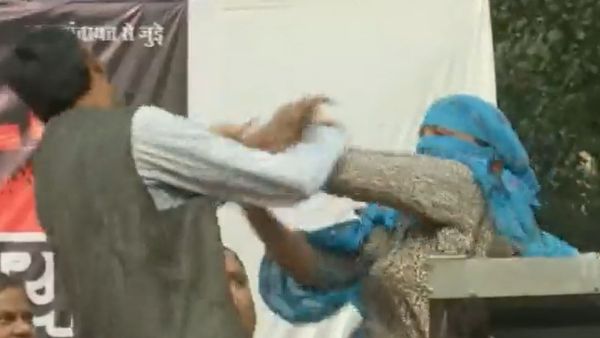 Woman climbs up the stage of Hindu Ekta Manchs program and hits a man with her slippers Woman climbs up the stage of Hindu Ekta Manchs program and hits a man with her slippers
