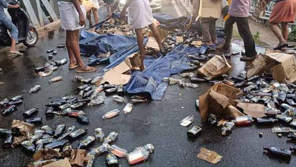 After a lorry of liquor bottles overturned in Kerala, the locals picked up the liquor bottles After a lorry of liquor bottles overturned in Kerala, the locals picked up the liquor bottles