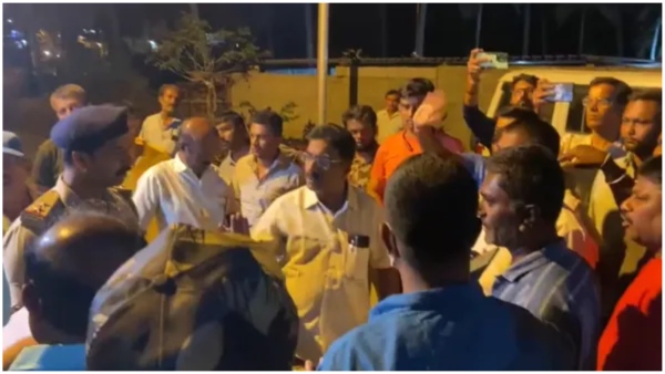 Opposition party leaders holding bundles of sarees to distribute to voters near Bengaluru