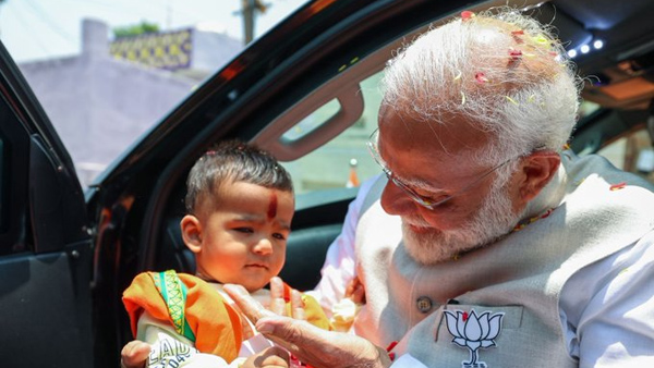 A photo of Prime Minister Narendra Modi picking up a boy is going viral on social media