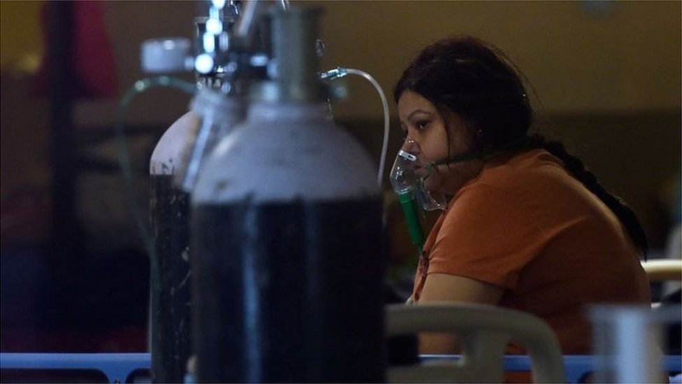 ఆక్సిజన్ సిలిండర్ సహాయంతో శ్వాస పీల్చుకుంటున్న కరోనా రోగి