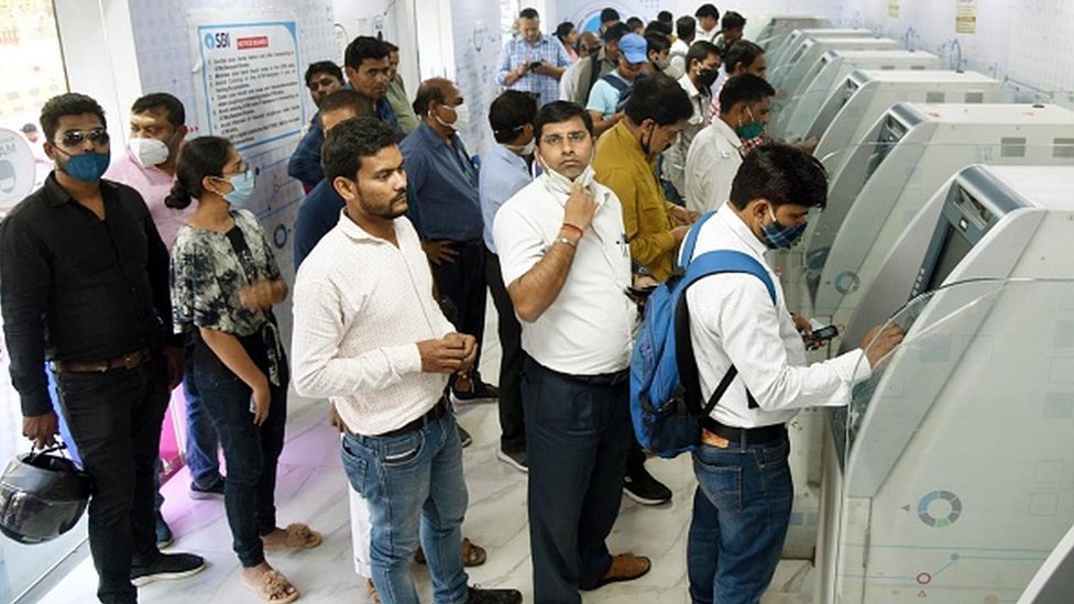 ఏటీఎంలో డబ్బులు తీస్తున్న ఖాతాదారులు