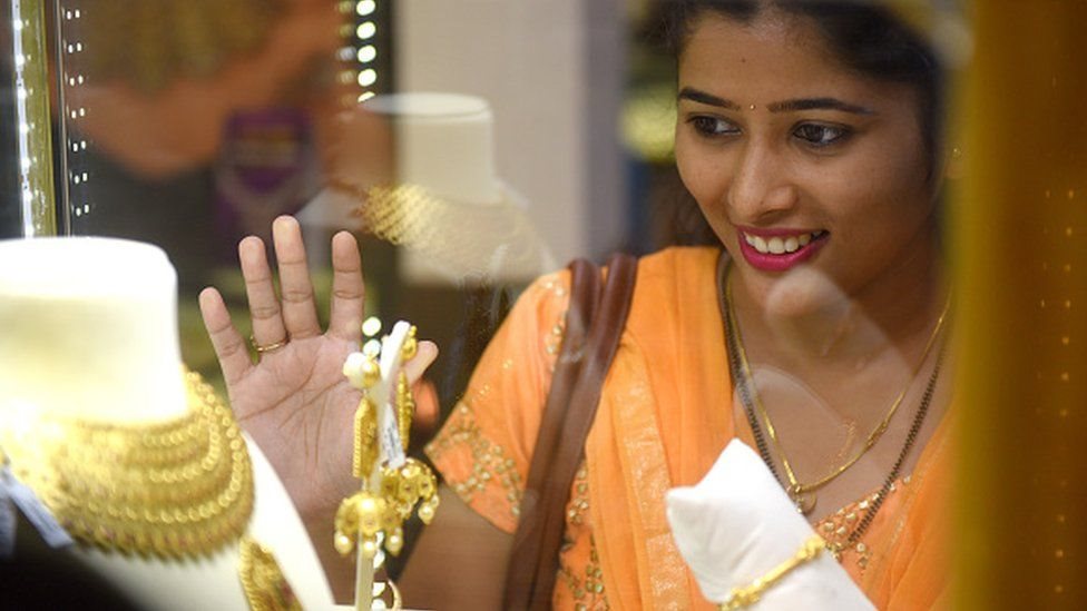బంగారు నగలను చూస్తున్న మహిళ