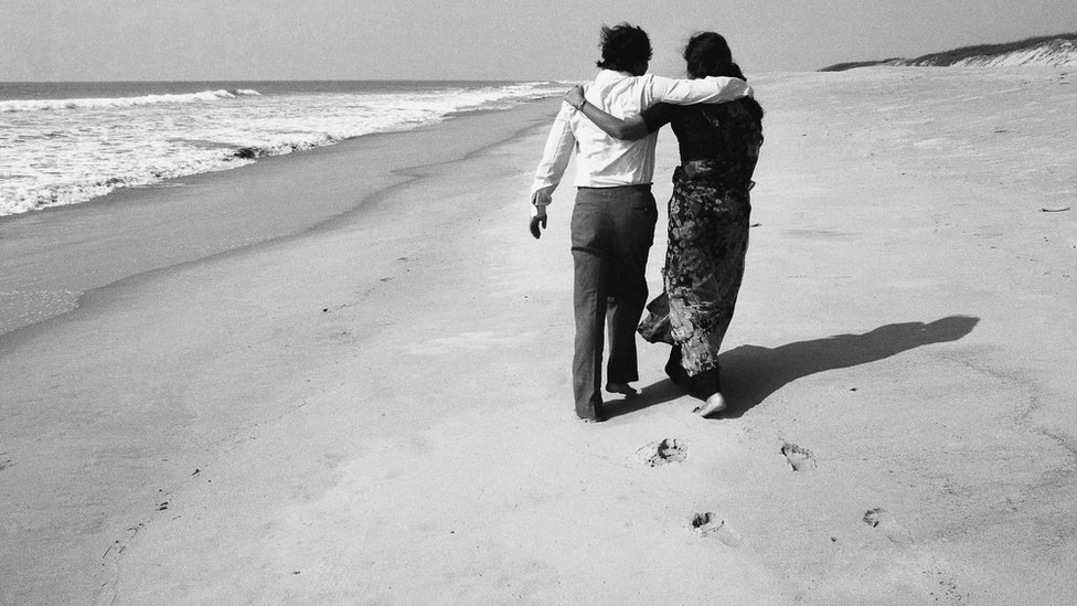 సముద్ర తీరంలో నడుస్తున్న జంట