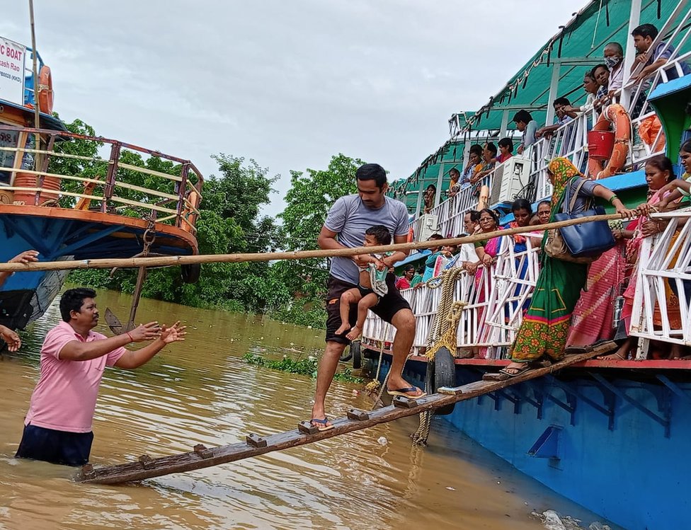 వరదలో చిక్కుకున్న ప్రజలను సురక్షిత ప్రాంతాలకు తరలిస్తున్న ఆంధ్రప్రదేశ్ ఫైర్ సర్వీసు సిబ్బంది