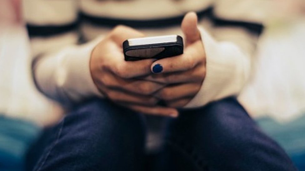 A woman looks at her phone