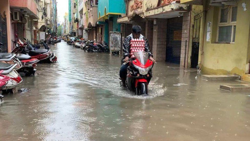 వరద నీటిలో బైకు నడుపుతున్న వ్యక్తి